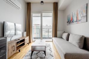 ein Wohnzimmer mit einem Sofa und einem TV in der Unterkunft Seba Suites with Fitness And Pool in Istanbul