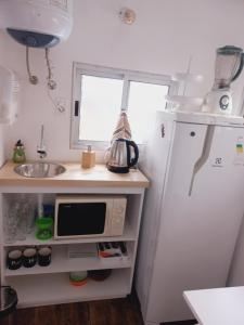 a small kitchen with a refrigerator and a sink at Bluetres B&B in Balneario Buenos Aires
