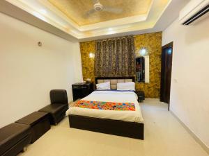 een slaapkamer met een bed en een bank erin bij Hotel Taj Star by Urban stay in Agra