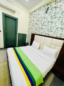 - une chambre avec un grand lit et une couverture colorée dans l'établissement Hotel Taj Star by Urban stay, à Agra
