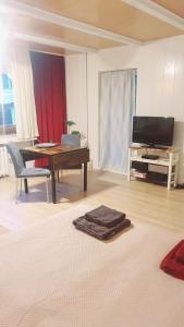 a living room with a desk and a table and a television at Apartment Buckow in Buckow