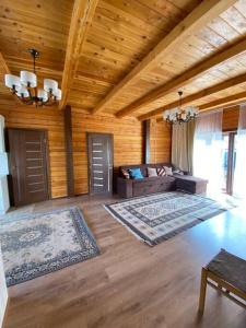 a large living room with wooden walls and wooden floors at Сруб на Иссык Куле in Chon-Sary-Oy