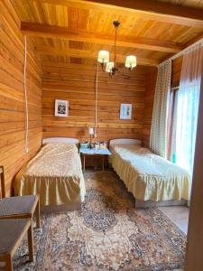 Chon-Sary-Oy的住宿－Сруб на Иссык Куле，木制客房内的一间卧室配有两张床