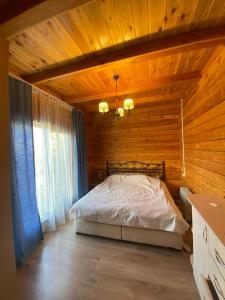 Chon-Sary-Oy的住宿－Сруб на Иссык Куле，木制客房内的一间卧室,配有一张床