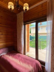 a bedroom with a window with a bed in front of it at Сруб на Иссык Куле in Chon-Sary-Oy