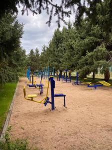 a playground with blue and yellow equipment in a park at Сруб на Иссык Куле in Chon-Sary-Oy