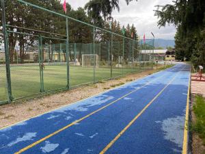 Chon-Sary-Oy的住宿－Сруб на Иссык Куле，一座带围栏的空篮球场和一个网球场