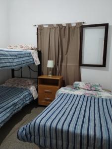 1 dormitorio con 2 camas, vestidor y ventana en Buenas Vibras en Villa Carlos Paz