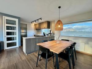 uma cozinha e sala de jantar com uma mesa de madeira e cadeiras em Cabañas Los Coihues em Puerto Natales