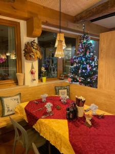 a dining room with a table with a christmas tree at Kapriol in Castello Tesino