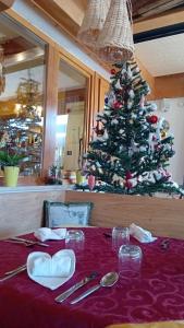 una mesa con un árbol de Navidad en un restaurante en Kapriol, en Castello Tesino