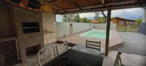 a patio with a swimming pool and a house at Casa de praia in Palhoça