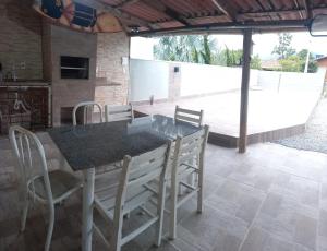 una sala da pranzo con un tavolo e alcune sedie di Casa de praia a Palhoça