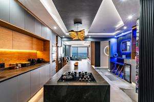 a kitchen with a stove and a blue wall at Modern Chic Beachfront Apartment in Ballito