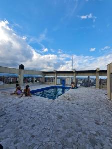 un groupe de personnes assises autour d'une piscine dans l'établissement Departamento completo 1D en Barrio Sur con cochera privada, à San Miguel de Tucumán