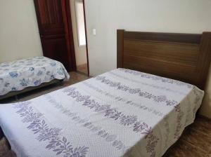1 dormitorio con 1 cama con manta blanca y morada en Casa Temporada em Alto Caparaó, en Caparaó Velho