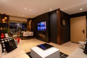 een woonkamer met een bank en een tv bij Privilege house Opale in Marrakesh