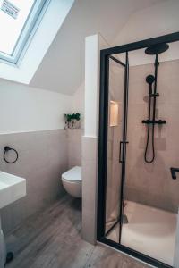 a bathroom with a toilet and a glass shower at The Loft Studio apartment - above detached new build garage in Llanymynech