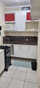 a kitchen with white cabinets and a sink and a stove at 507 - Apto completo p temporada ou negócios - PVH in Porto Velho