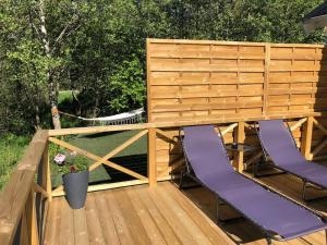 a wooden deck with two purple chairs on it at Modern house on the countryside in lovely Bohuslän in Uddevalla