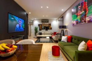 een woonkamer met een groene bank en een televisie bij Privilege house Opale in Marrakesh
