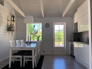 a dining room with a table and chairs and a kitchen at Modern house on the countryside in lovely Bohuslän in Uddevalla