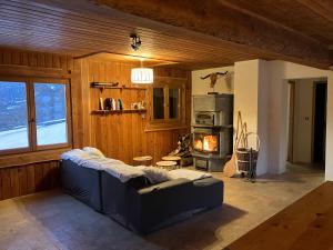 a living room with a blue couch and a stove at Chalet d'alpage Le Lauzeron in Aiguilles