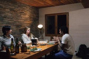 un grupo de tres personas sentadas en una mesa en Chalet d'alpage Le Lauzeron, en Aiguilles