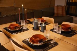 a table with candles and plates and cups on it at Chalet Auroras - Top quality 2 bdr chalet in prime location of Levi in Levi