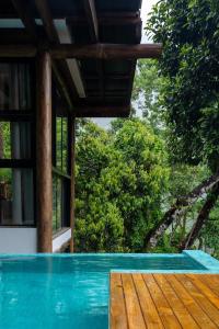 uma casa com piscina com árvores ao fundo em Casa Waimea em Ubatuba