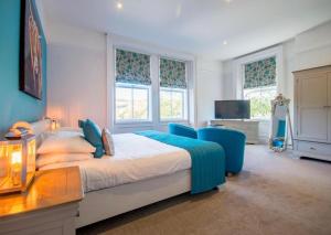een slaapkamer met een bed, een bureau en 2 ramen bij Armstrong Manor in Rothbury