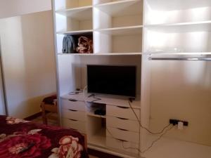 a living room with a tv on a white shelf at Vida nada me debes in Ostende