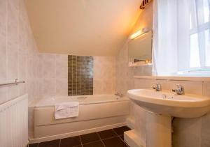 een badkamer met een wastafel, een bad en een wastafel bij Armstrong Manor in Rothbury