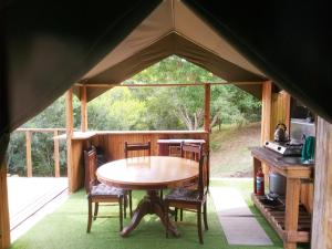 Zelt mit Tisch und Stühlen in einem Zimmer in der Unterkunft Wilderness Glamping Tents in Wilderness