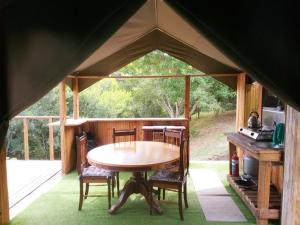 a tent with a table and chairs in a room at Wilderness Glamping Tents in Wilderness