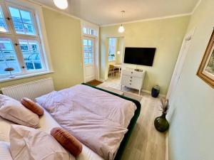 1 dormitorio con 1 cama y TV en Hirtshals Gamle Station, en Hirtshals