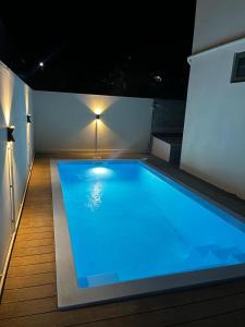 een groot zwembad op een patio 's nachts bij Les Olives in Flic-en-Flac