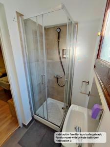 a shower with a glass door next to a sink at Madrid Centro Rooms in Madrid
