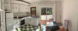 ラ・オロタバにあるCasa Lauraの白いキャビネットとチェッカーフロア付きのキッチン