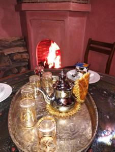 马拉喀什Riad Lounge à Marrakech的壁炉旁的桌子上放着茶壶和玻璃杯
