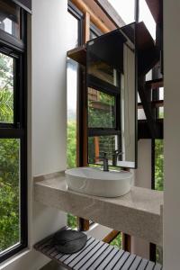 uma casa de banho com um lavatório e uma grande janela em Casa Waimea em Ubatuba