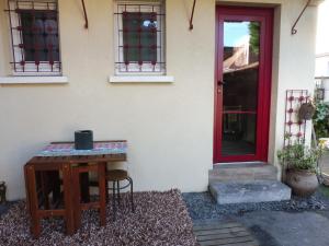 een tafel voor een huis met een rode deur bij Gure Doya in Billère