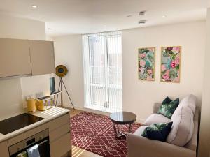 uma sala de estar com um sofá e uma mesa em Urban Gateway Spacious Apartment with free parking em Bracknell