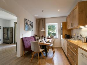 a kitchen and dining room with a table and chairs at Landhaus 1896 in Kössen +3 photos