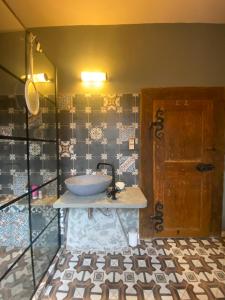 ein Badezimmer mit einem Waschbecken auf der Theke und einer Tür in der Unterkunft Magical suite in a historical rectory house 