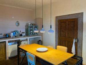 eine Küche mit einem Holztisch mit Stühlen und Lampen in der Unterkunft Magical suite in a historical rectory house 
