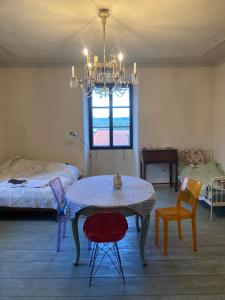Zimmer mit einem Tisch, einem Bett und einem Kronleuchter in der Unterkunft Magical suite in a historical rectory house 