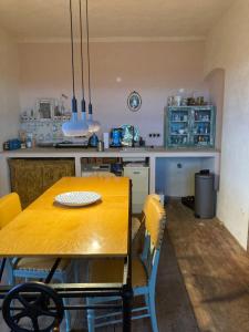 eine Küche mit einem Holztisch mit gelben Stühlen in der Unterkunft Magical suite in a historical rectory house 