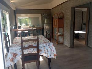 Manantiales的住宿－Casa en la Bota, Manantiales，一间设有桌子的房间和一间带桌椅的厨房