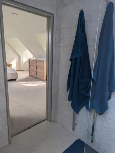 um espelho num quarto com uma toalha azul na parede em The Nest at Fairfield em Wargrave